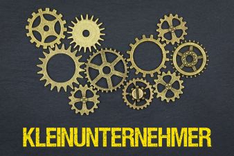 Foto: Zahnräder und Schriftzug Kleinunternehmer
